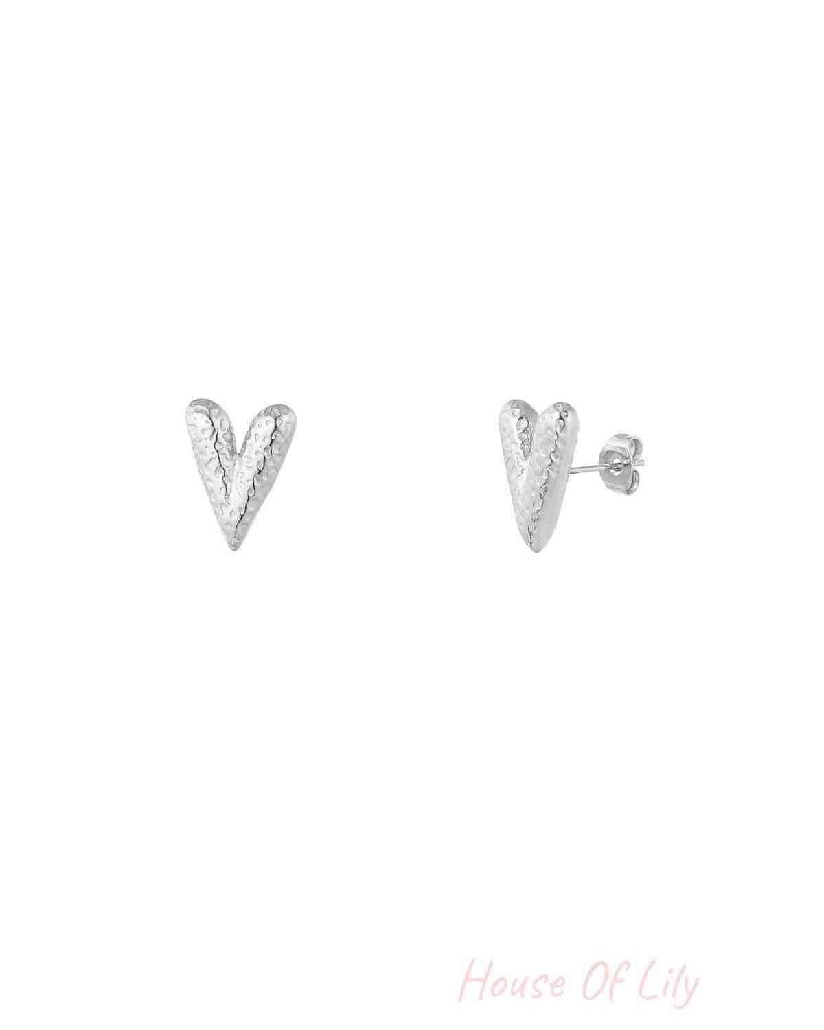 Pair of silver textured heart-shaped stud earrings with hammered finish on white background