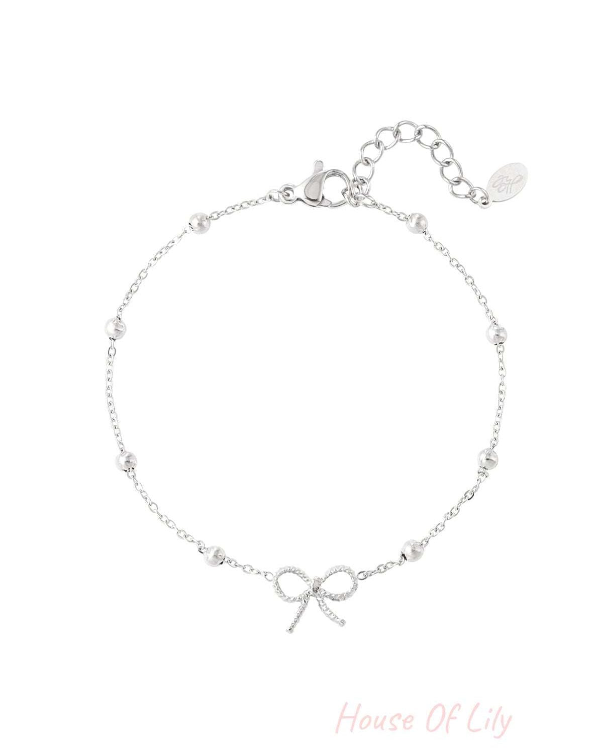 Silver-tone delicate bow charm bracelet with small spherical beads and adjustable chain on white background
