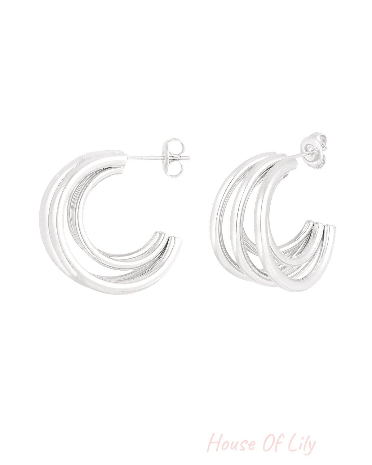 Polished silver tone triple loop hoop earrings isolated on white background showing design detail
