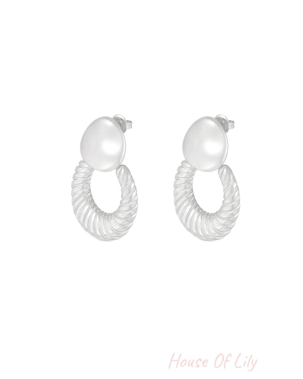 Pair of silver textured hoop stud earrings with smooth pebble-shaped studs on white background