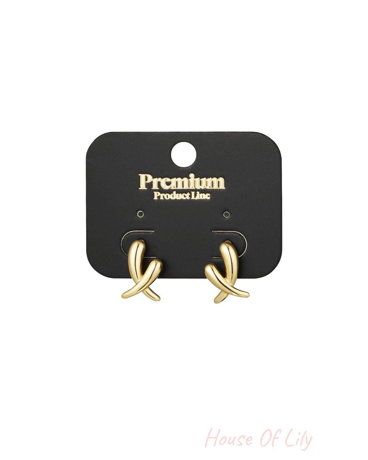Pair of gold crossed stud earrings displayed on a black Premium Product Line card