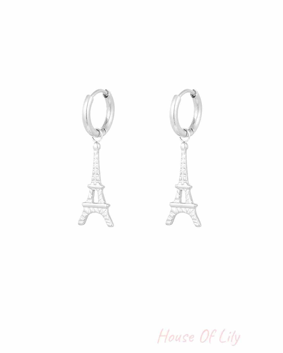 Pair of silver Eiffel Tower drop earrings on white background