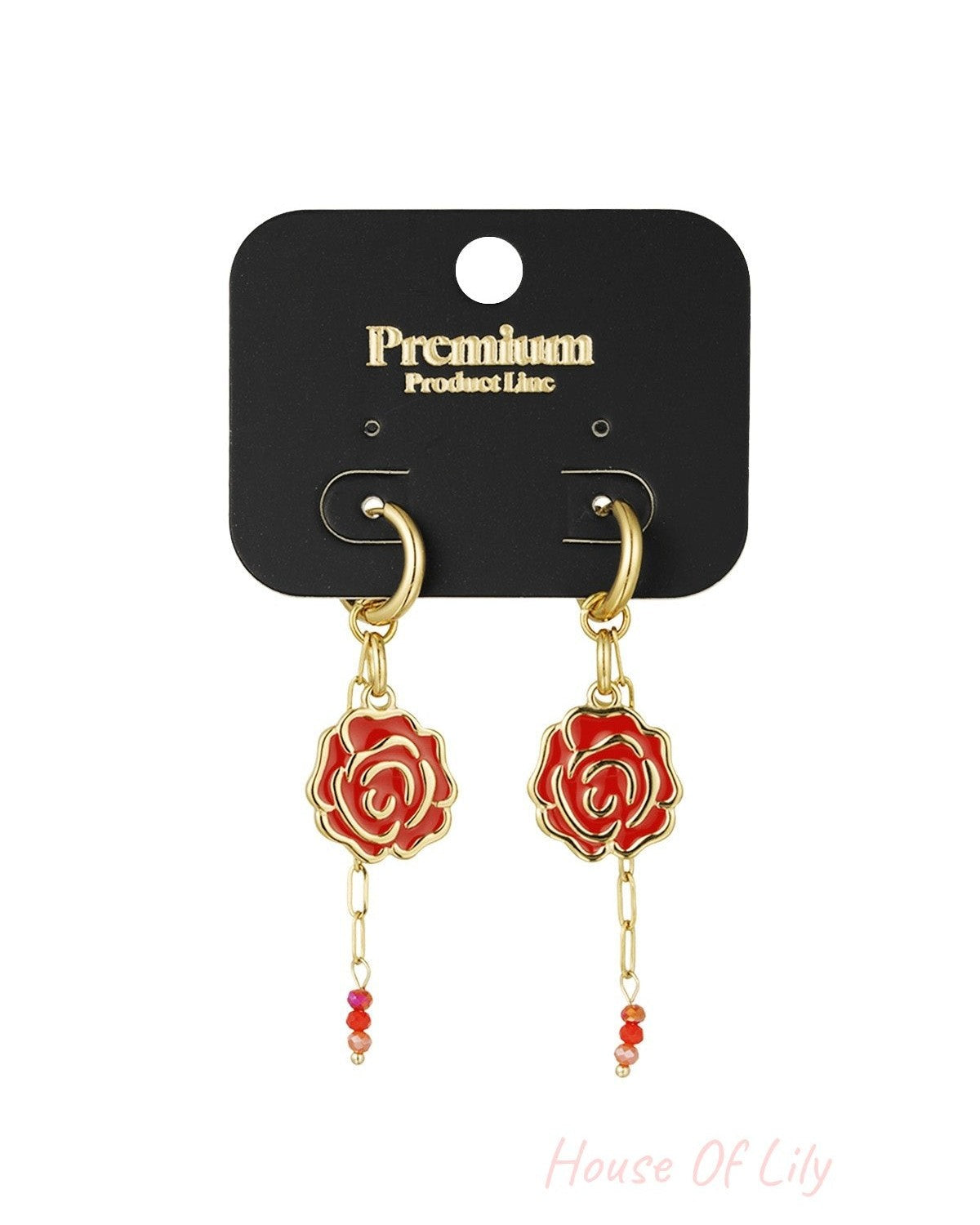 Pair of red enamel rose drop earrings with gold-tone hoops displayed on black premium product line card