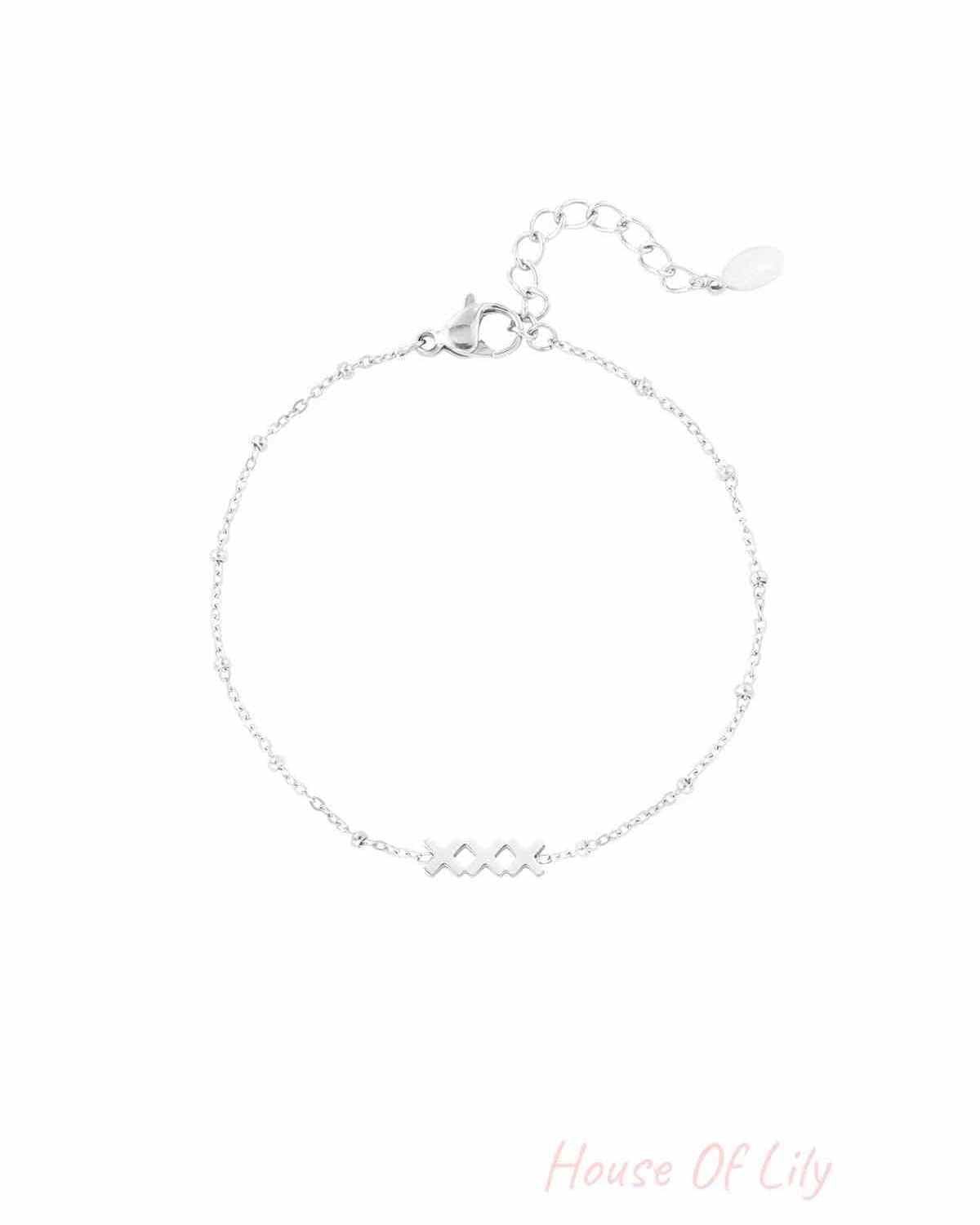 Close-up of a silver version of the minimalist 'XXX' charm bracelet on white background