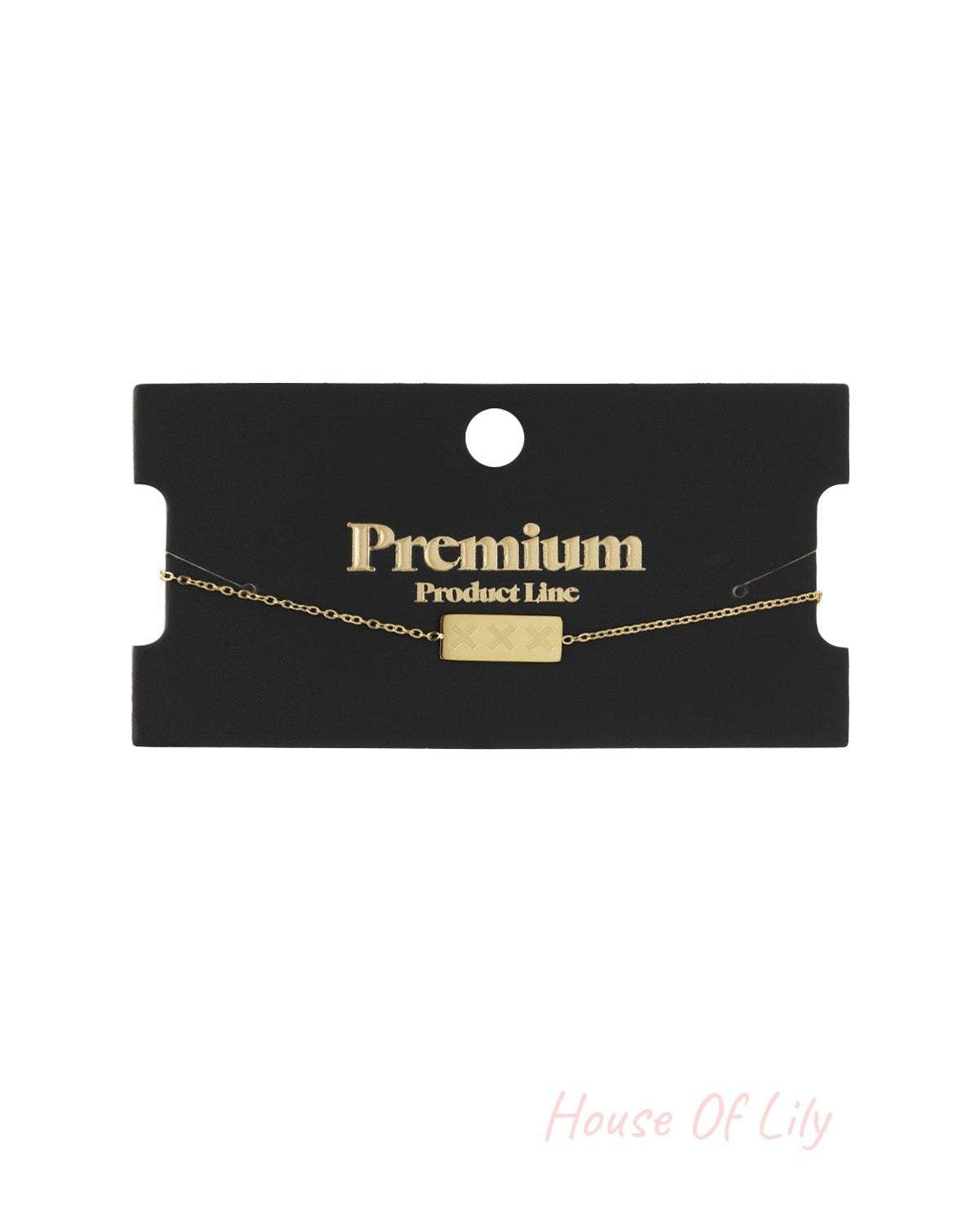 Gold triple X bracelet displayed on black Premium Product Line card
