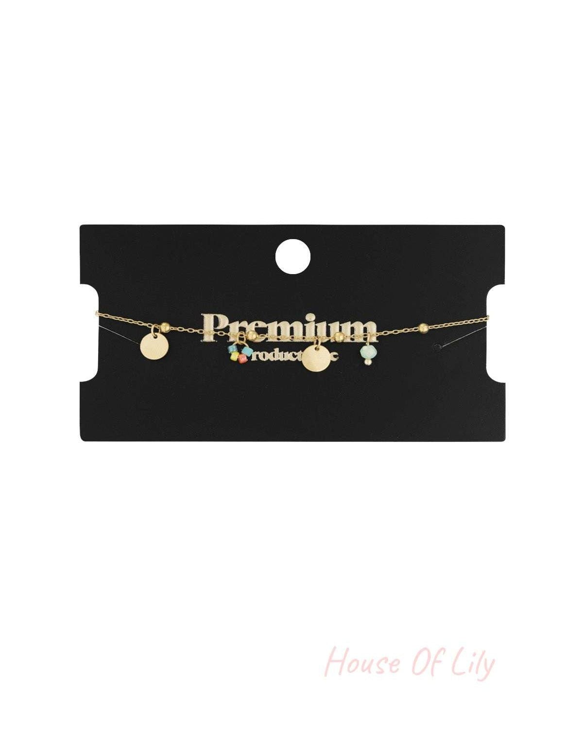 Gold coin bracelet delicately displayed on a black card with 'Premium' written in gold text