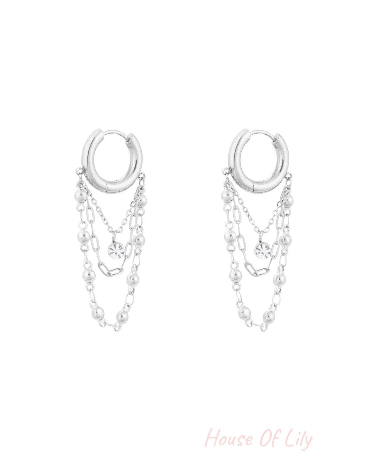 Silver chained hoop drop earrings with triple chains and rhinestone charm on white background
