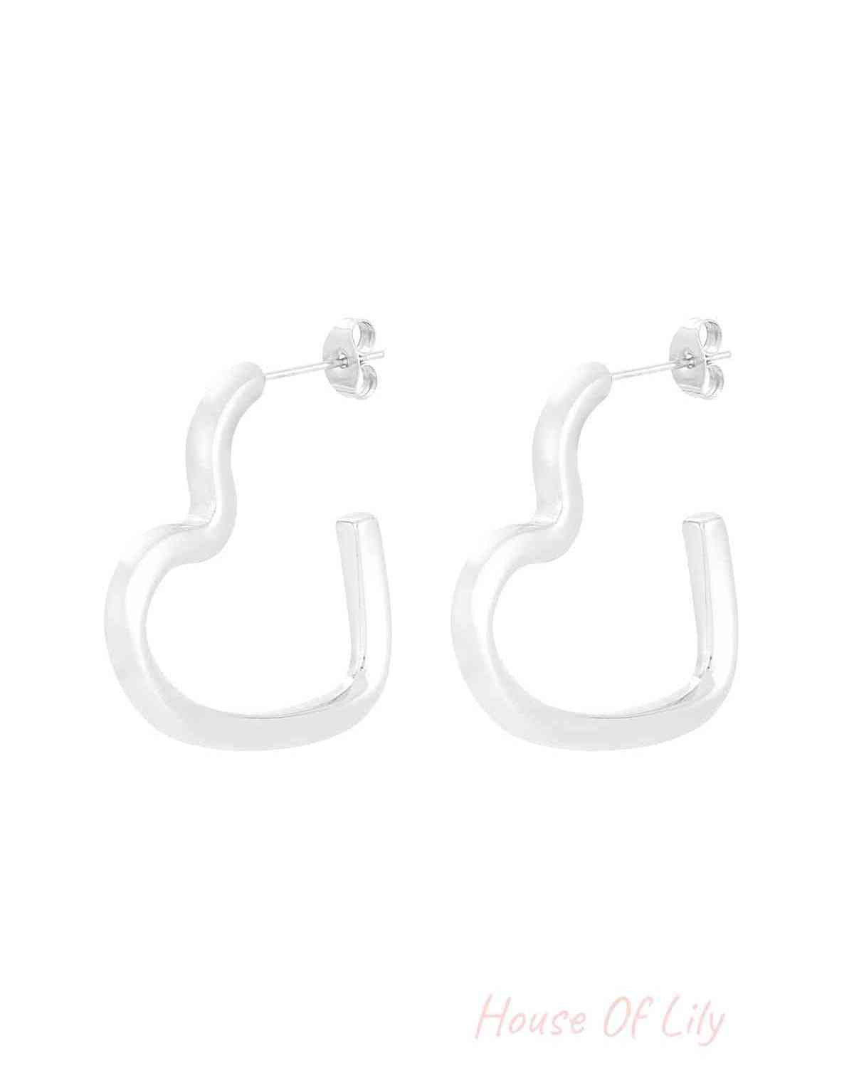 Pair of silver-toned wavy heart-shaped hoop earrings on white background
