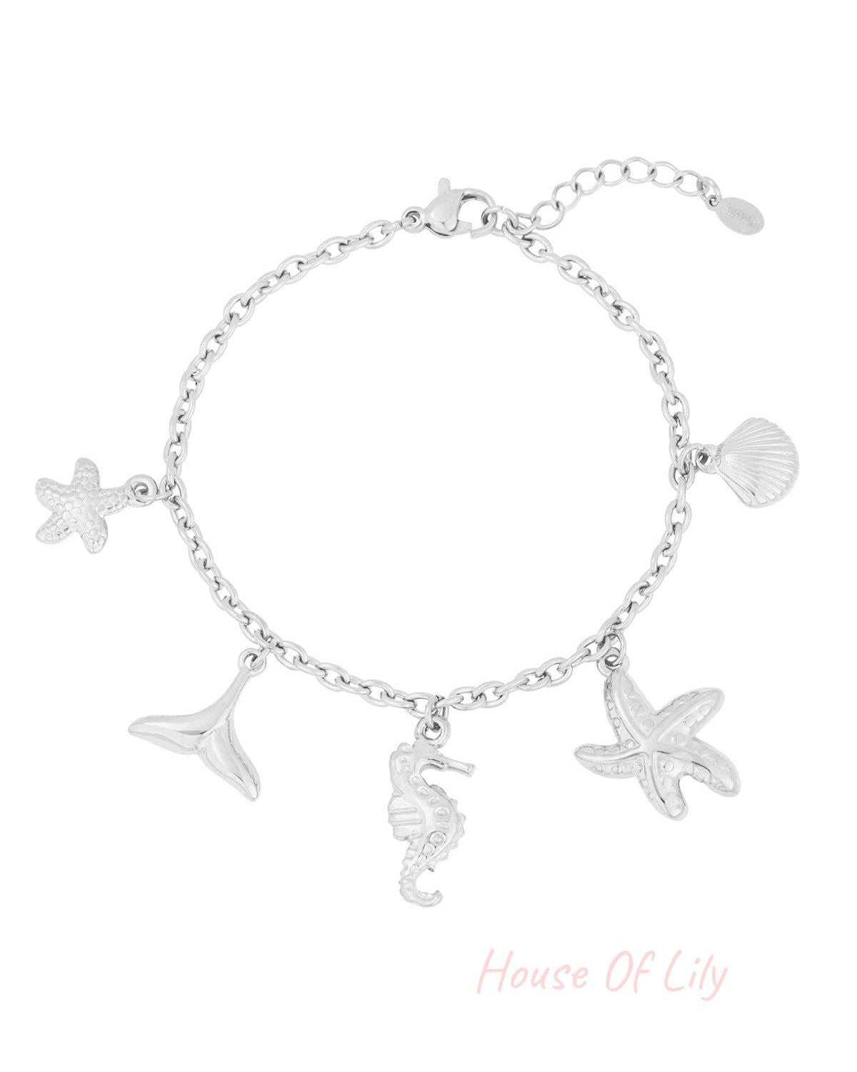 Silver-tone chain bracelet with ocean-themed charms including starfish, whale tail, seahorse, and shell on white background