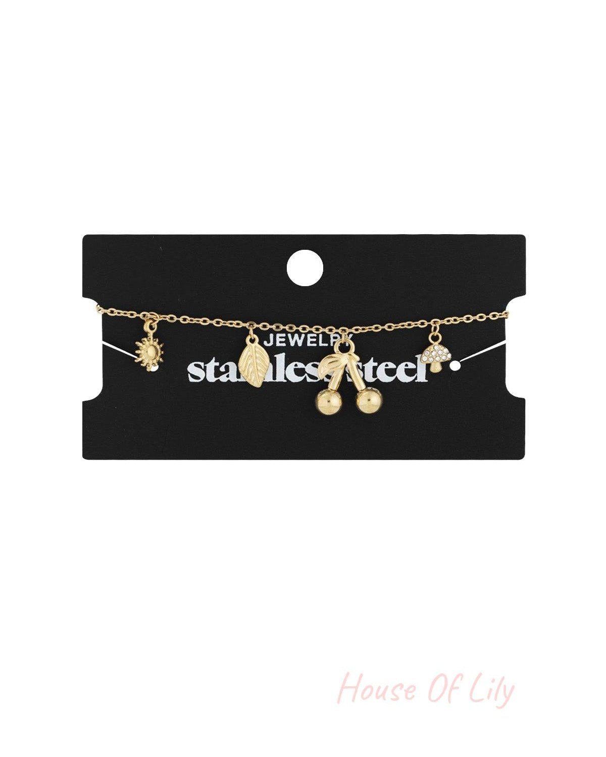 Gold charm bracelet displayed on black jewellery card labelled stainless steel