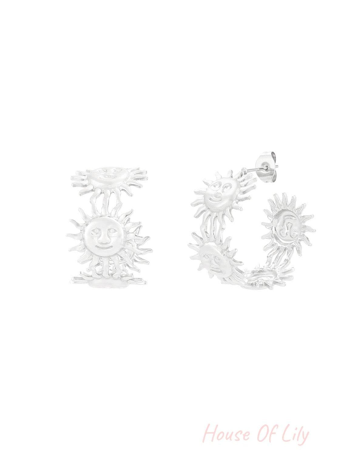 Silver-tone hoop earrings with playful sun face motifs displayed on white background