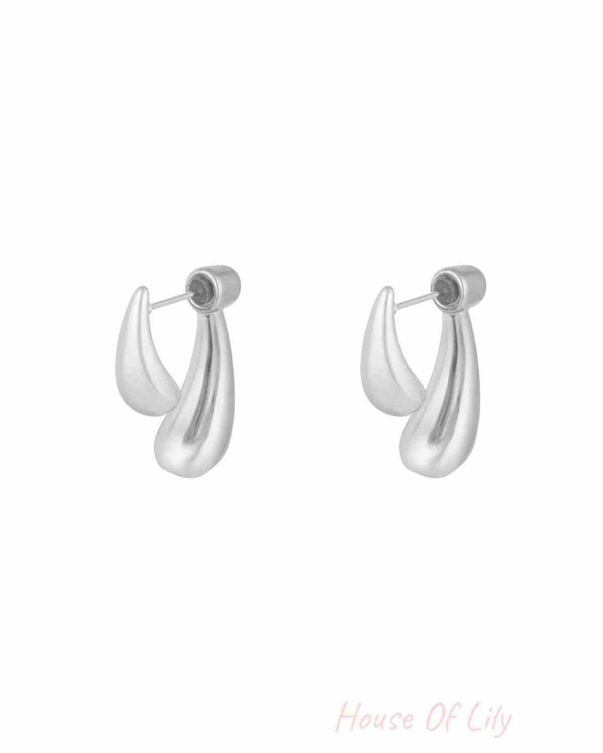 Silver sculptural stud earrings with abstract teardrop shapes on white background