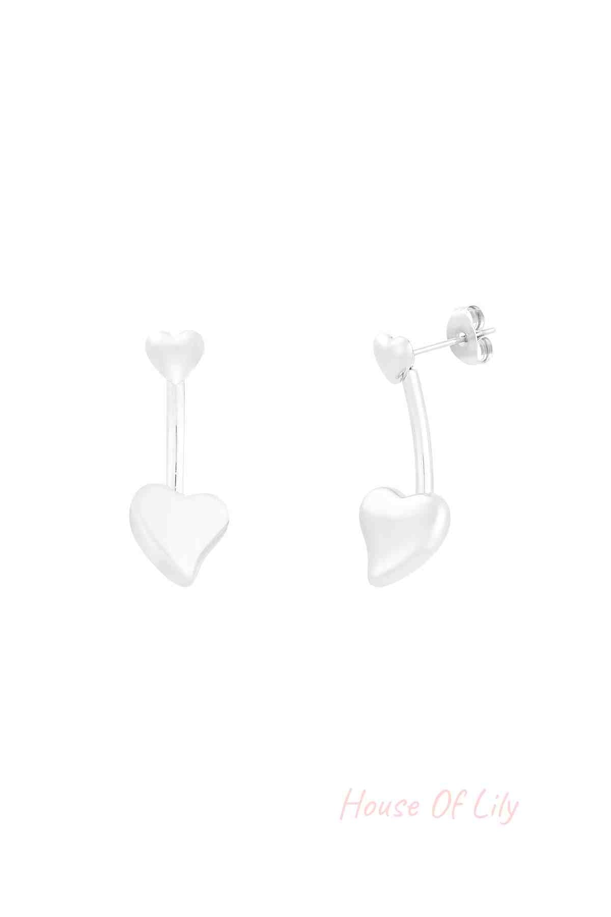 Close-up of silver double heart drop earrings with small heart stud and larger heart drop