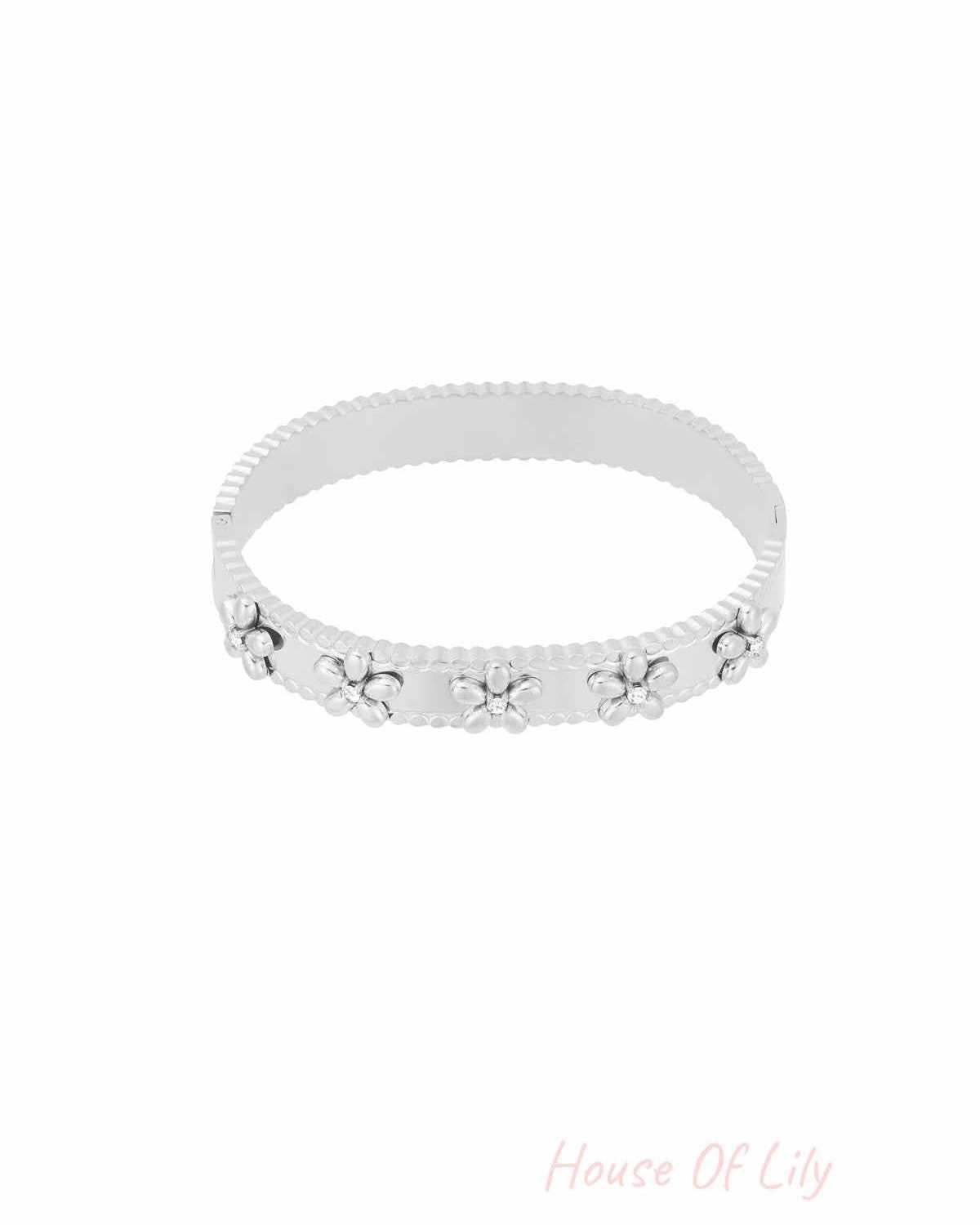 Silver floral bangle bracelet with rhinestone accents on white background
