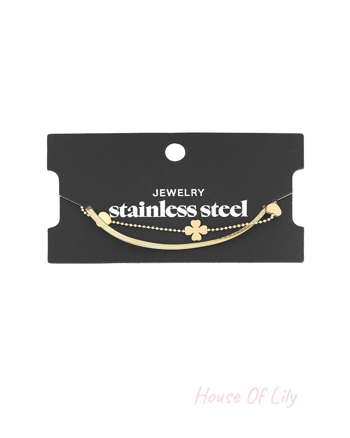 Gold layered charm bracelet displayed on a black card labelled stainless steel jewellery