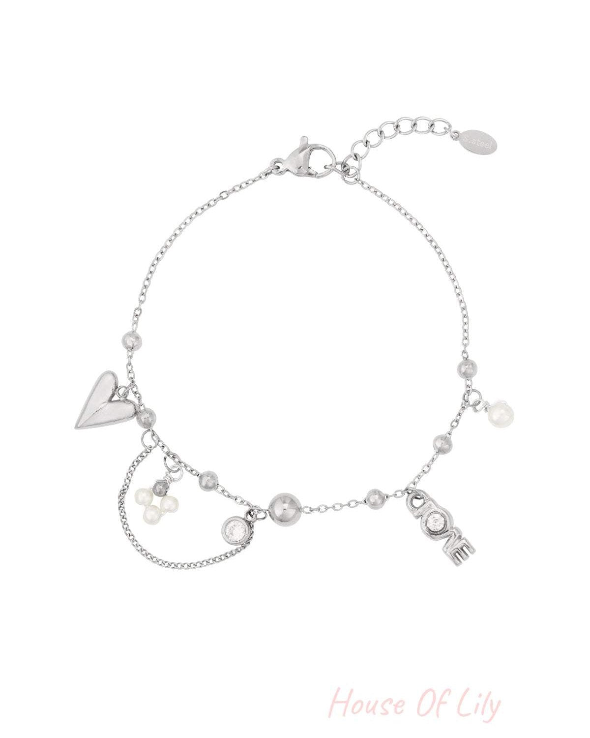 Silver-tone delicate charm bracelet featuring heart, pearl clusters, and LOVE lettering charm isolated on white background