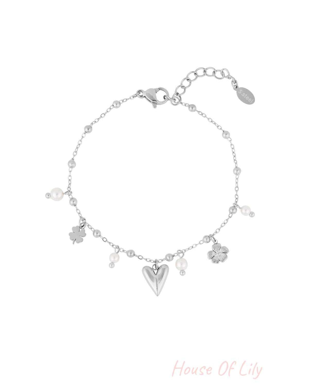 Silver-tone version of delicate charm bracelet with heart, flower, four-leaf clover charms and pearl accents on white background