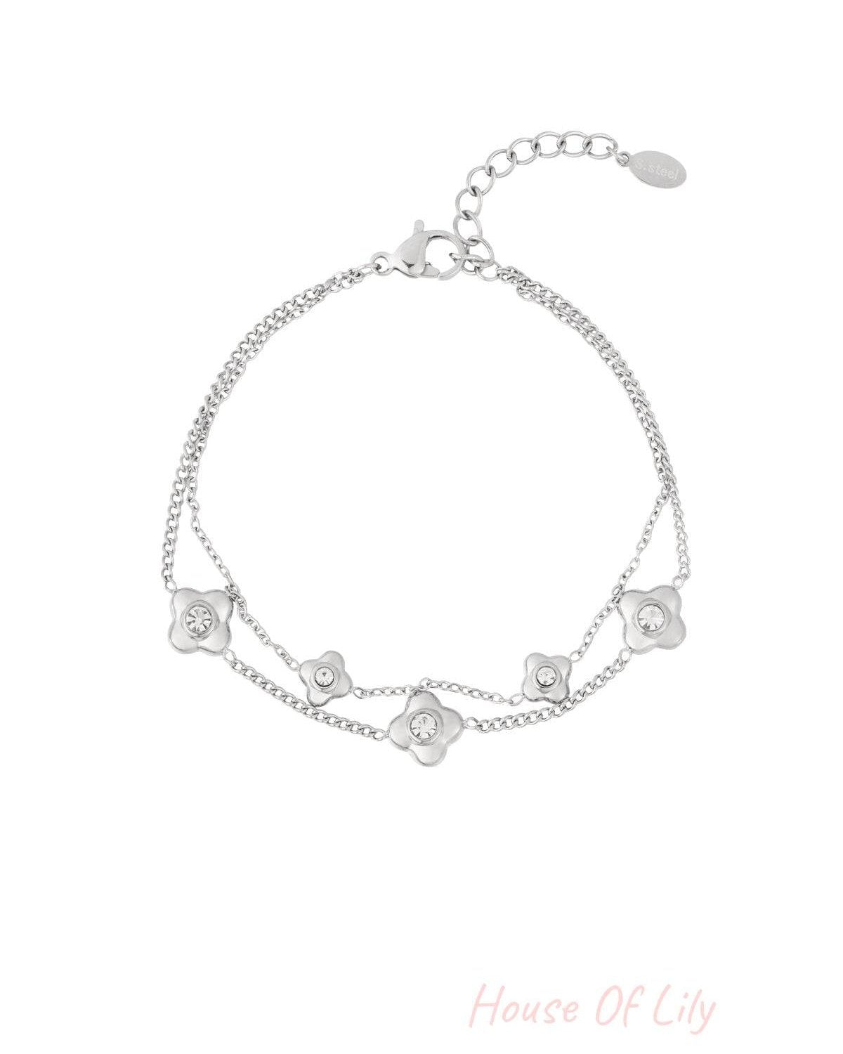 Silver double chain bracelet with flower shaped charms centered with crystals on white background