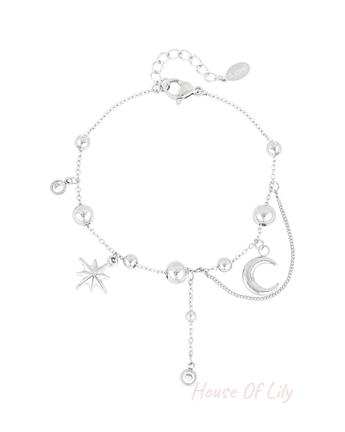 Silver celestial charm bracelet with moon, star, and bead charms on white background