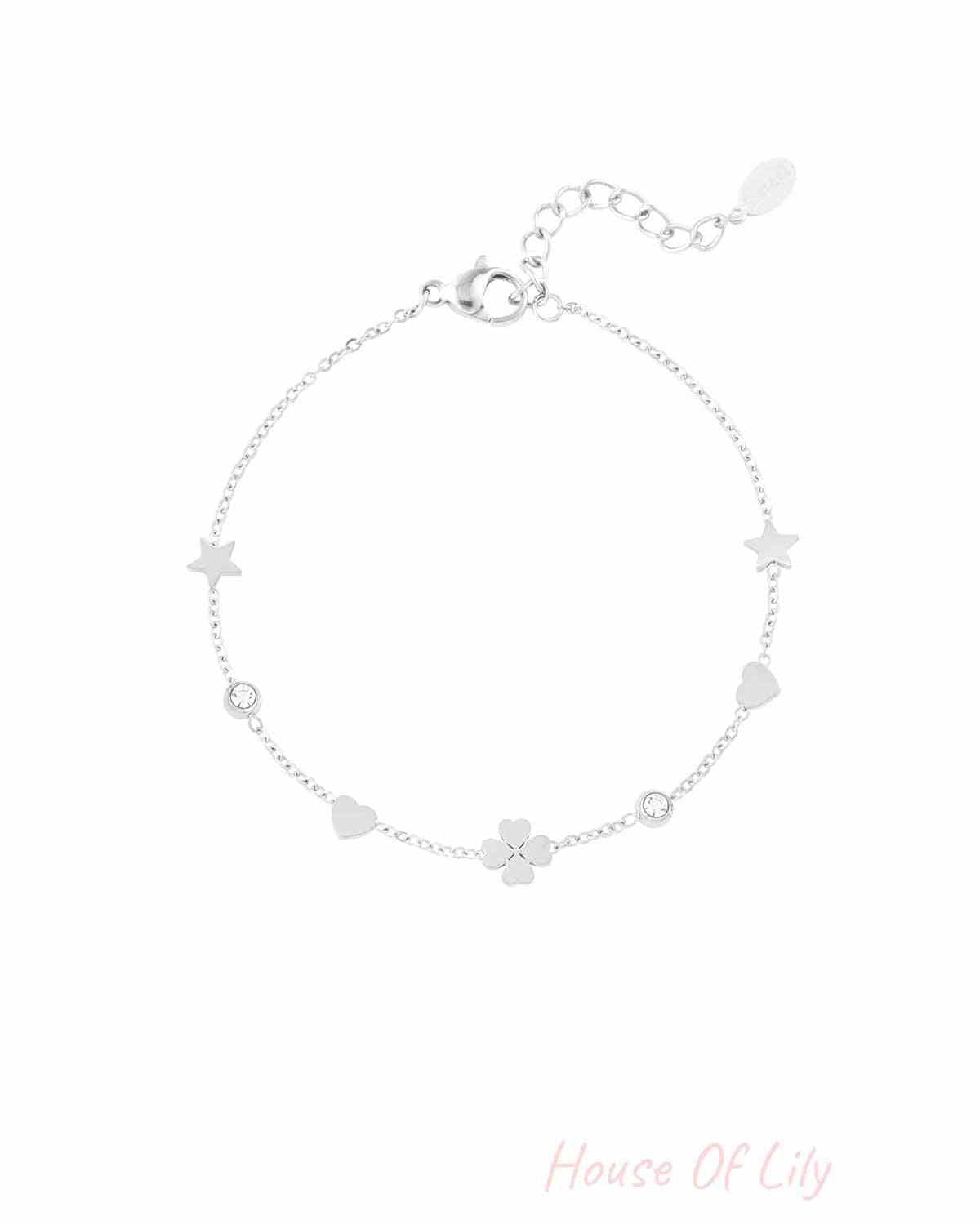 Silver-tone charm bracelet with star, heart, four-leaf clover and crystal accents laid flat with lobster clasp and adjustable links