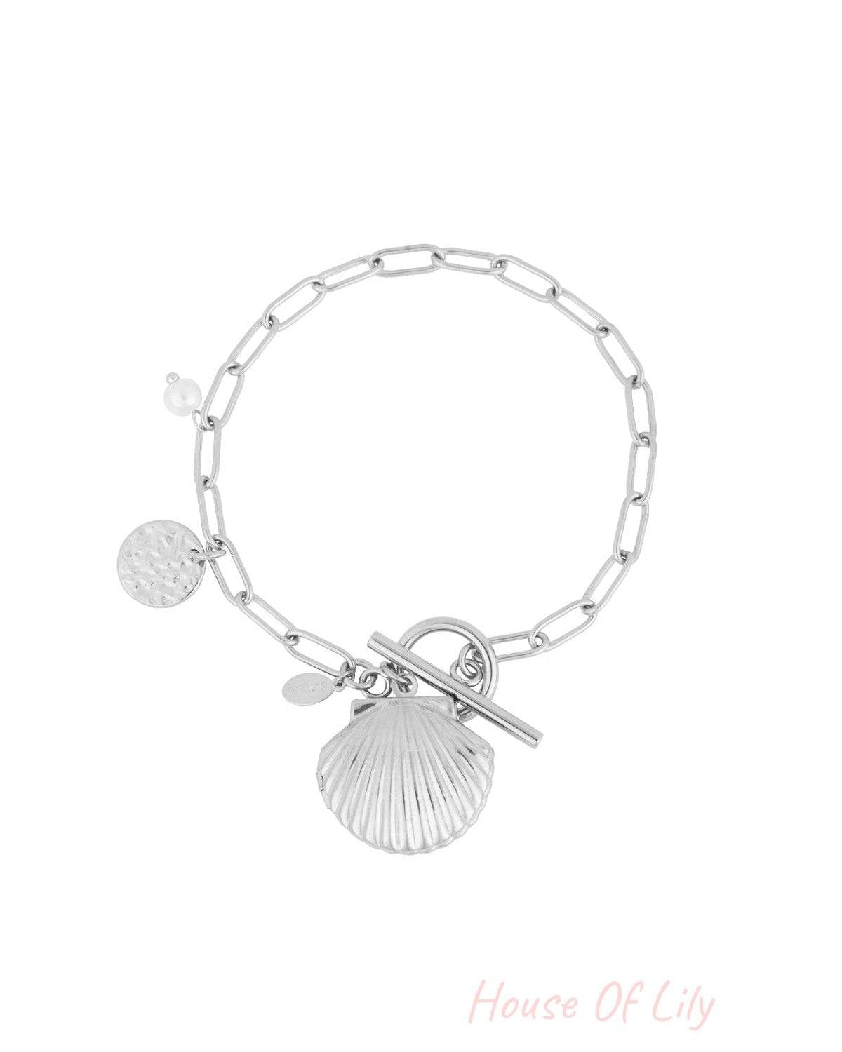 Silver-tone charm bracelet with shell pendant, pearl detail and toggle clasp on white background