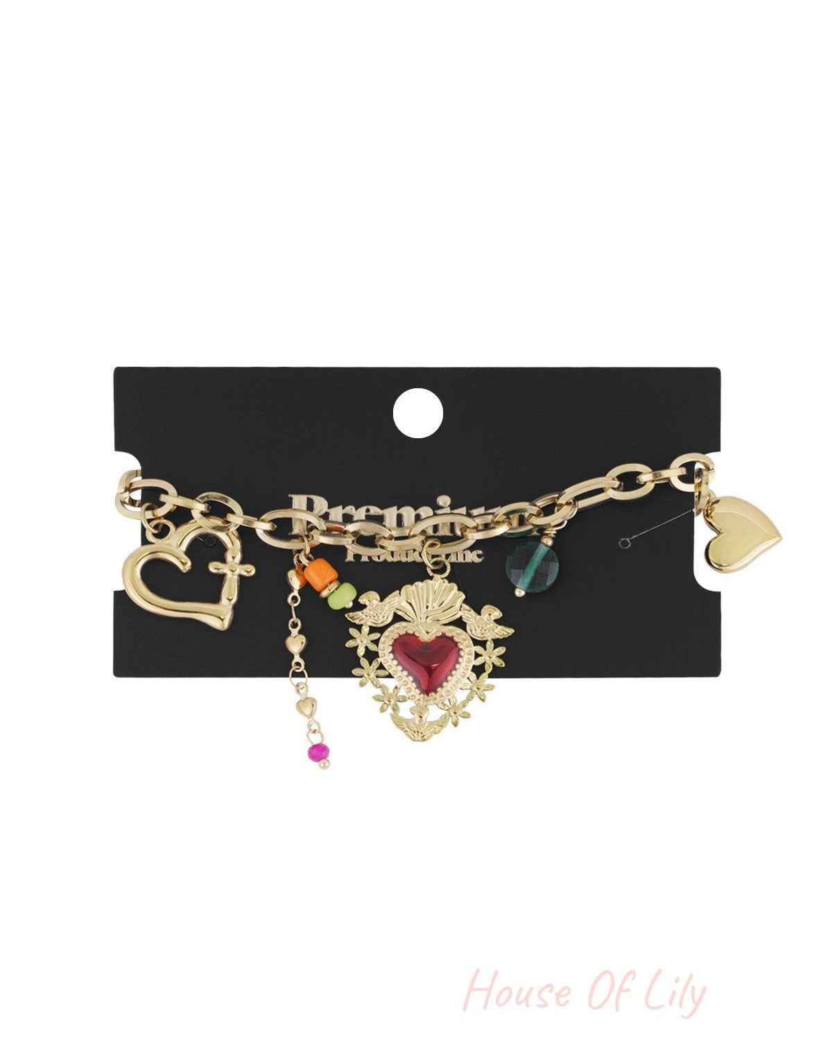 Gold charm bracelet displayed on black branded card showcasing multiple charms and lobster clasp