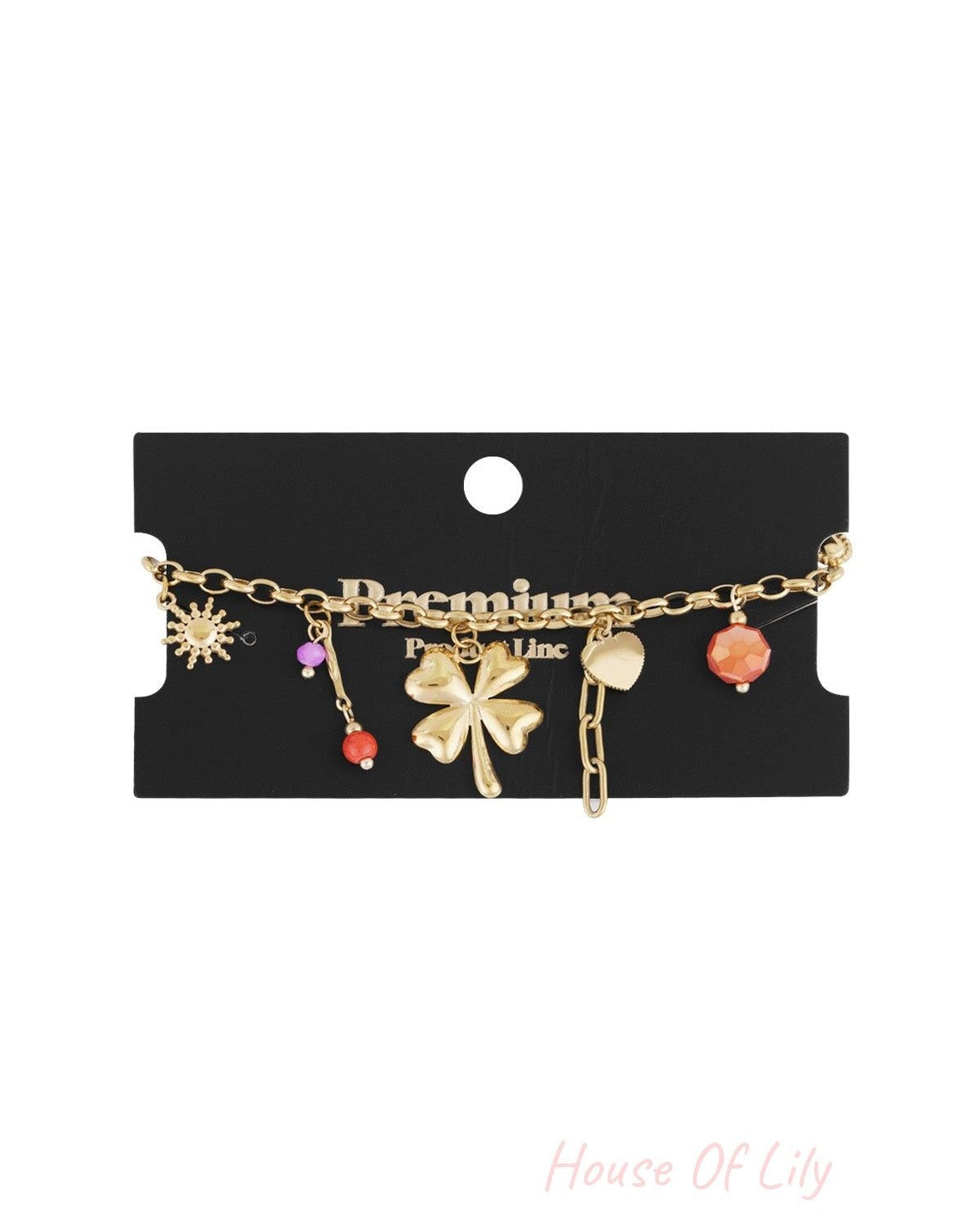 Gold charm bracelet displayed on black Premium packaging card