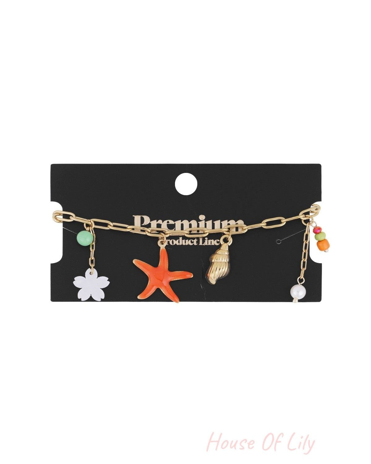 Gold-tone charm bracelet displayed on a black premium product line card with starfish and seashell charms visible