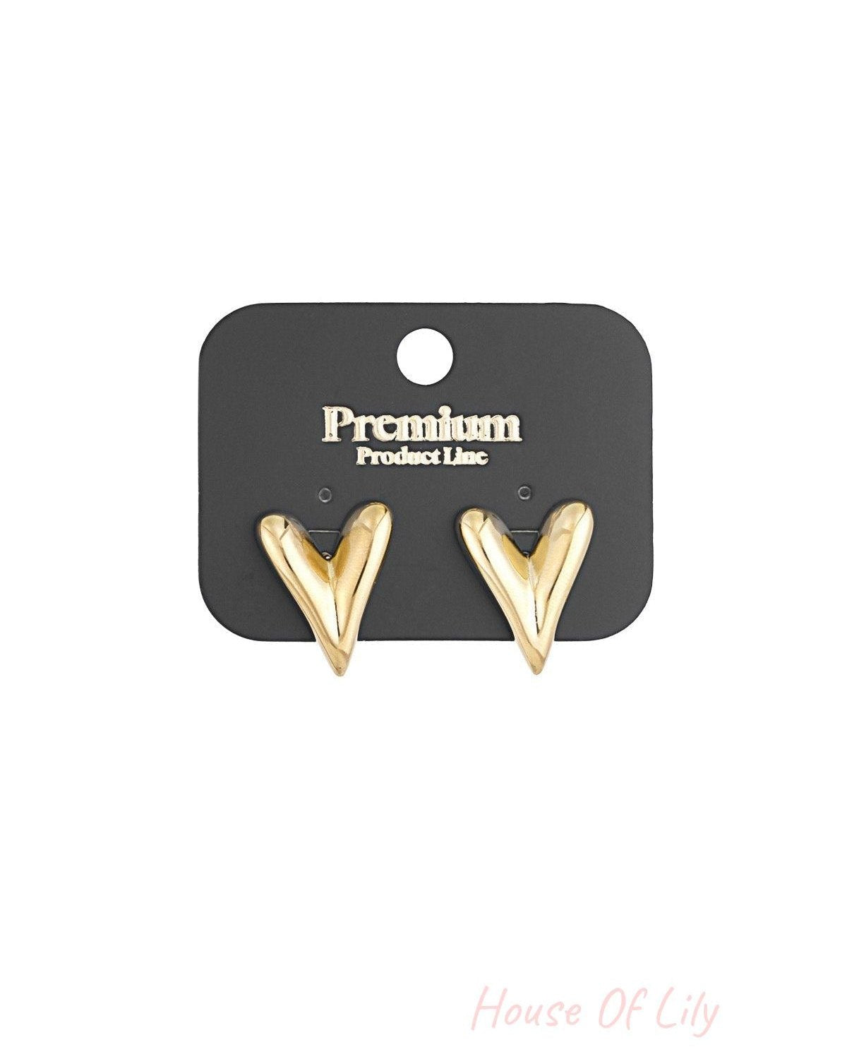 Gold heart stud earrings displayed on black Premium Product Line card