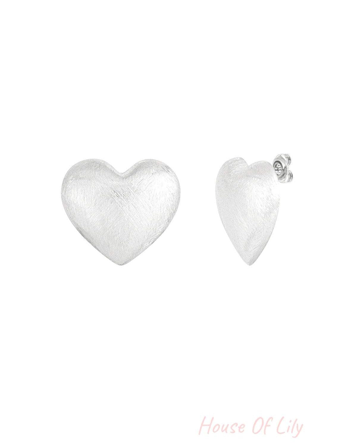 Pair of brushed silver-tone heart-shaped stud earrings shown from front and side angles