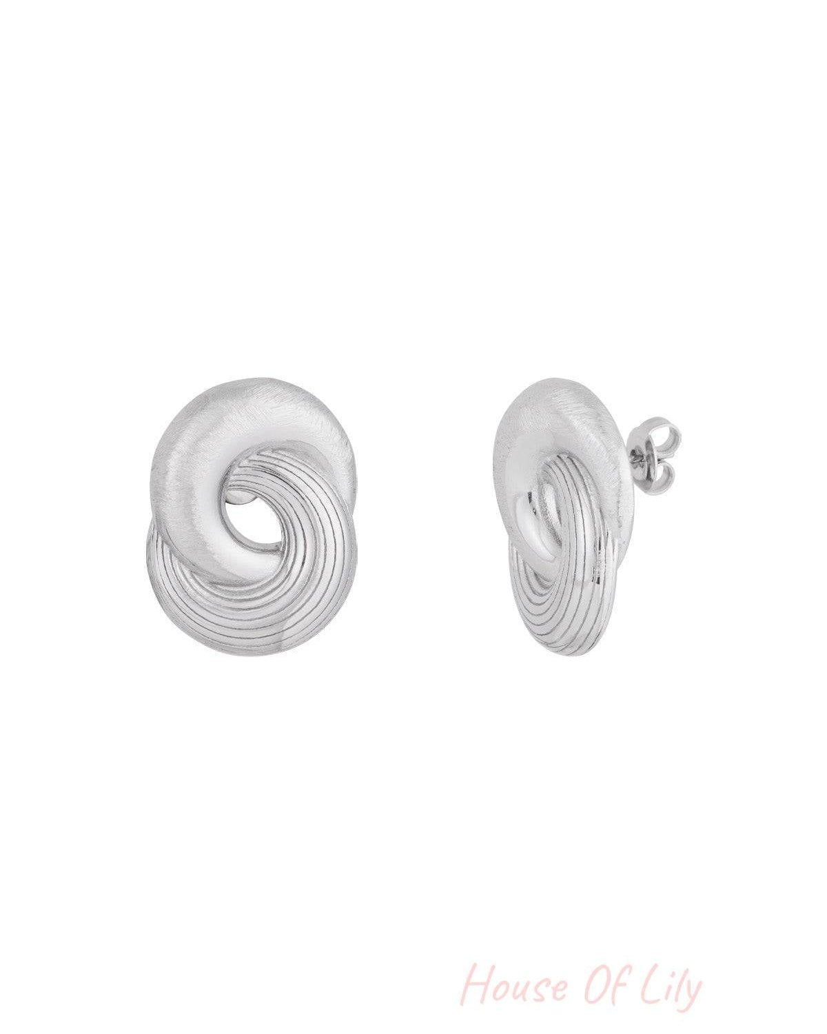 Pair of silver twist statement stud earrings with smooth and grooved texture shown from front and side