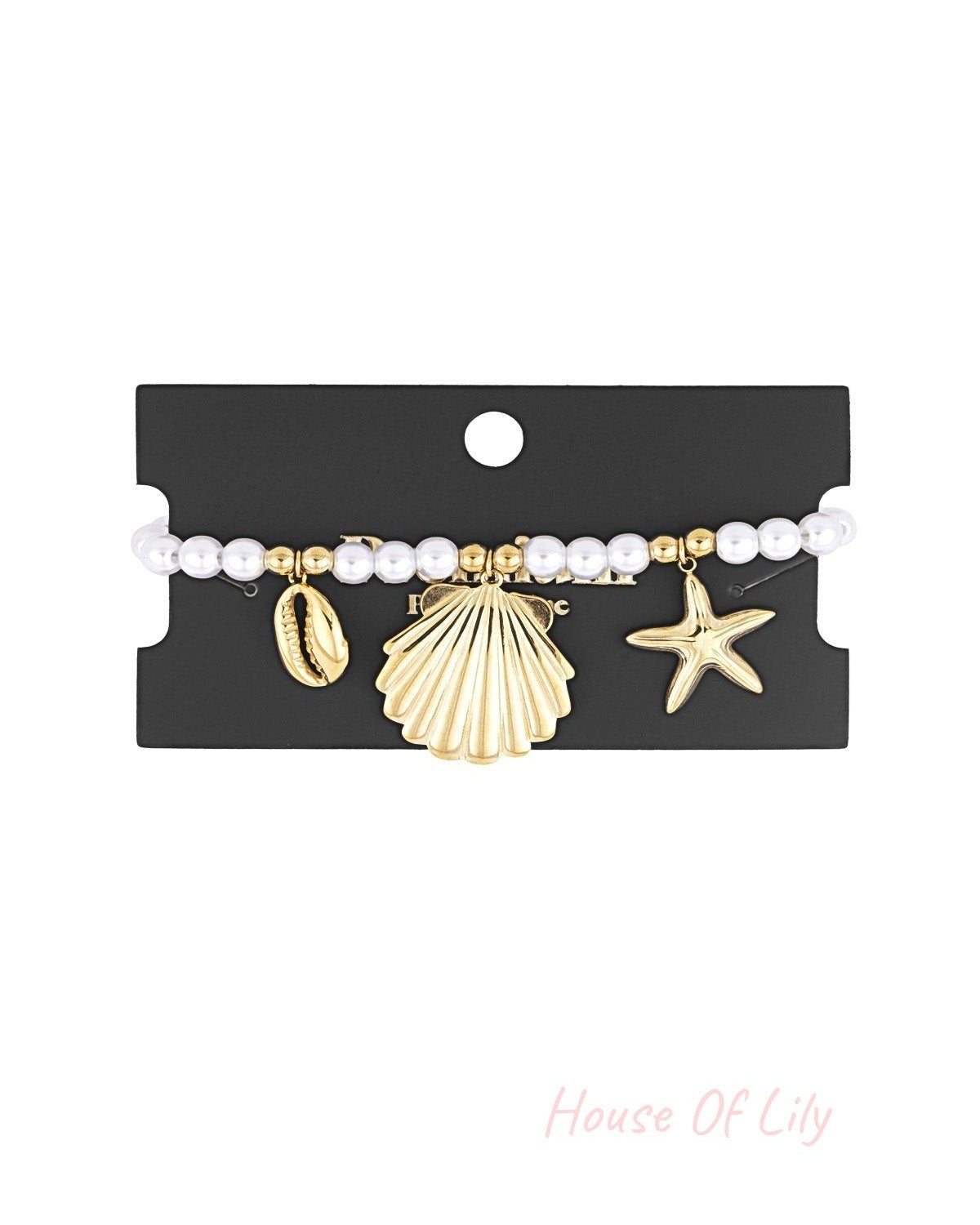 Pearl bracelet with gold-tone seaside charms displayed on black packaging card highlighting the braceletβs design