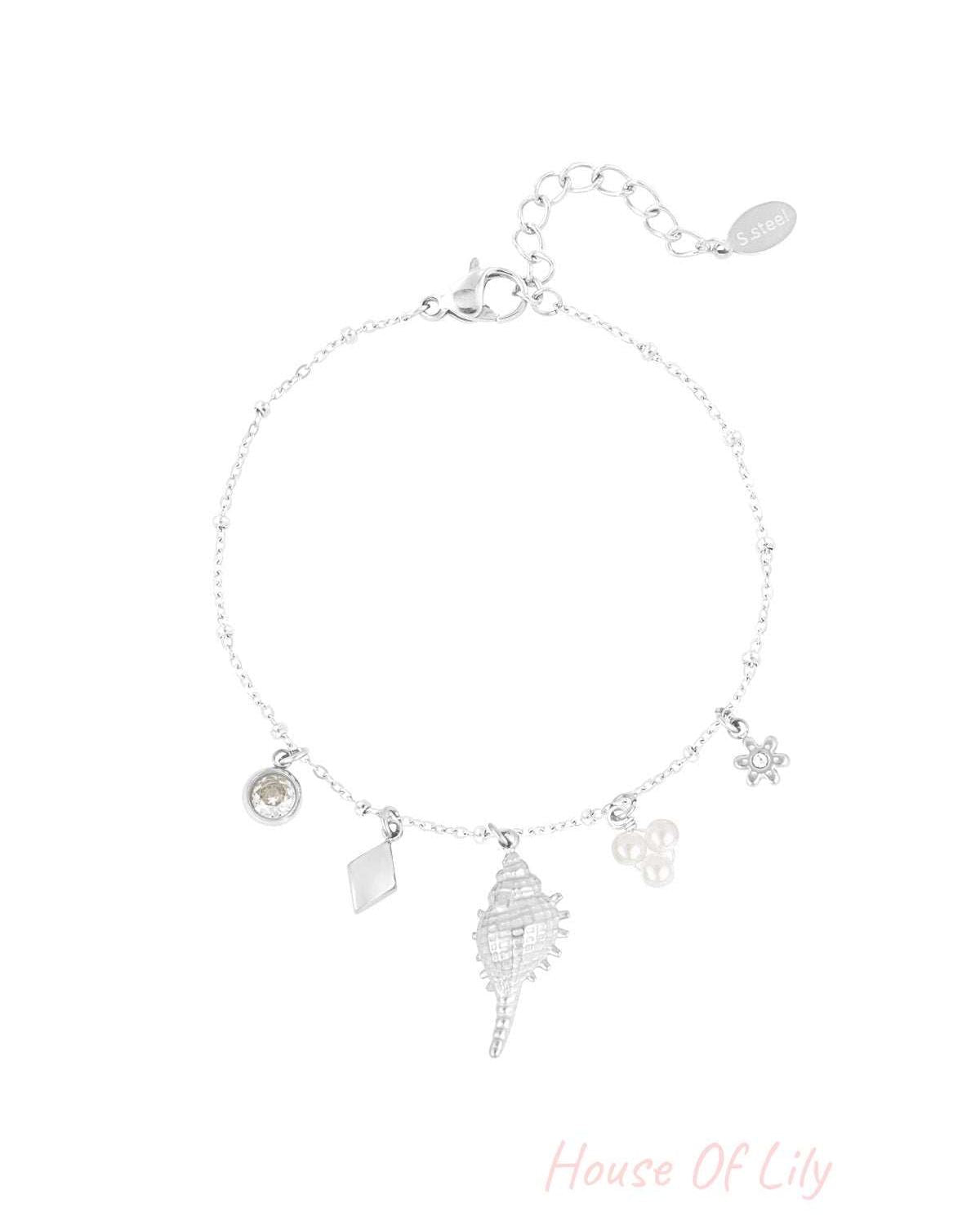 Silver-tone charm bracelet with the same assortment of crystal, rhombus, seashell, pearl cluster, and flower charms on a white background