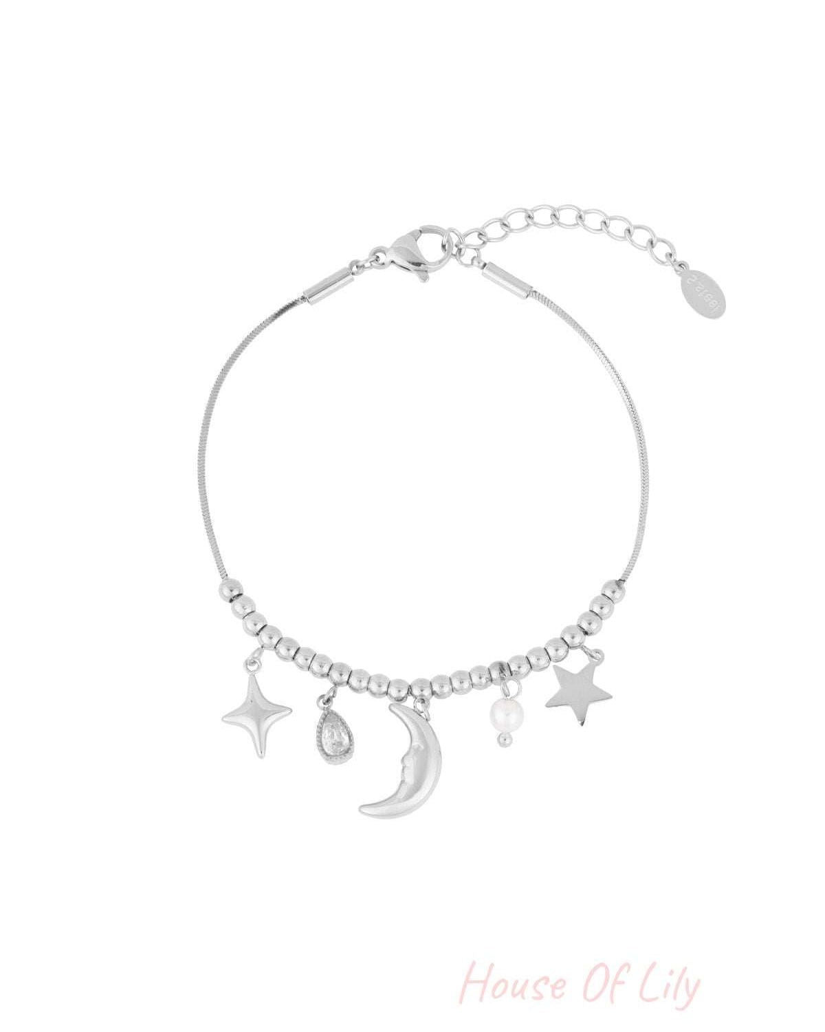 Silver celestial charm bracelet with moon, stars, pearl, and teardrop crystal charms on a beaded chain with adjustable clasp