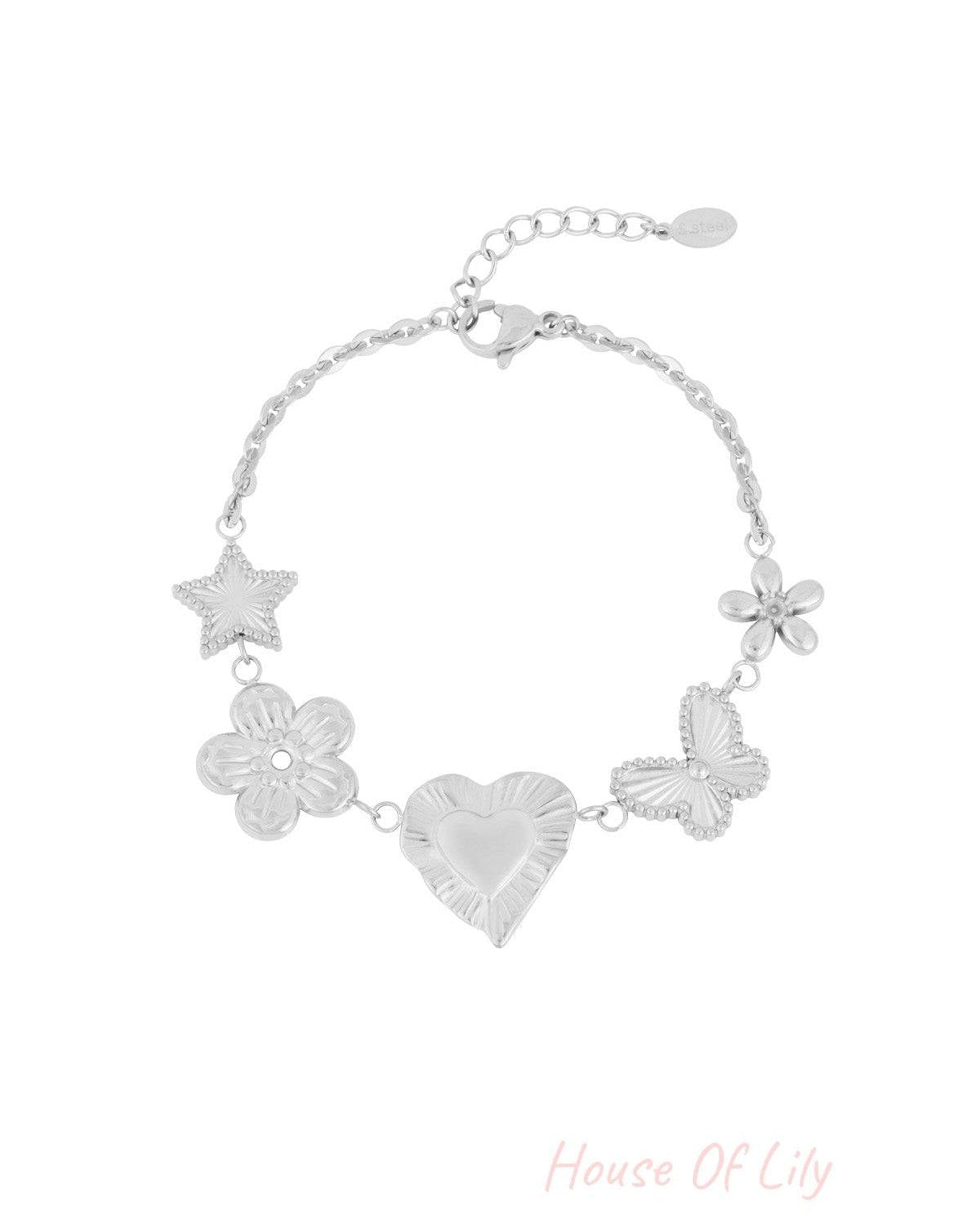 Silver charm bracelet with star, flower, heart, butterfly, and blossom motifs on white background