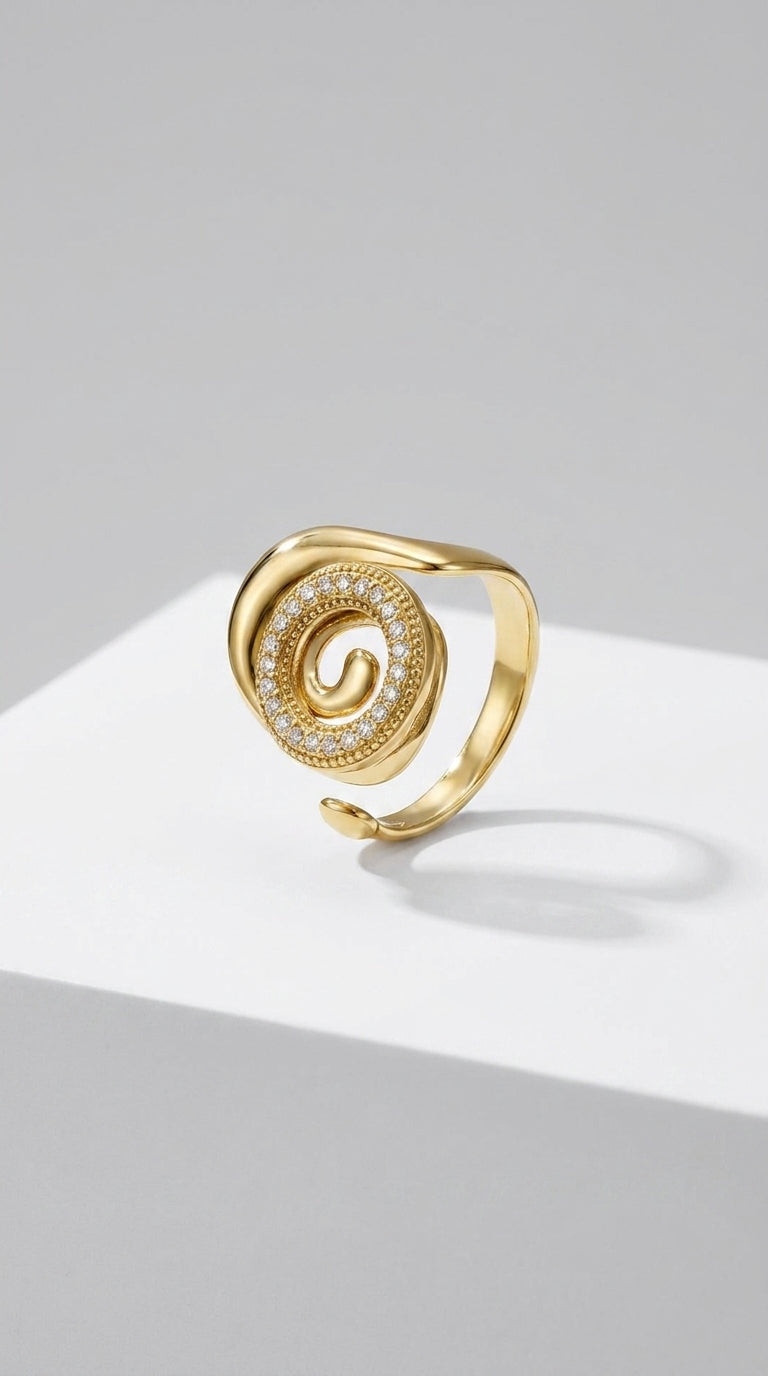 Gold Coastal spiral statement ring with a pavé-set diamond swirl on a smooth, curved band.