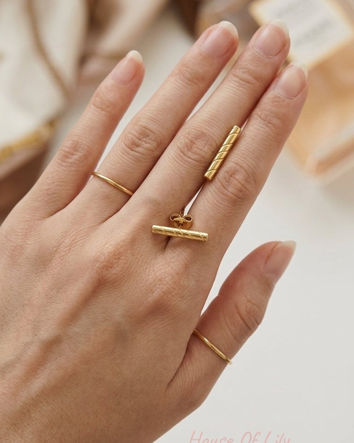 Gold-tone bar ring and matching earring set featuring a diagonal ribbed texture, styled with two slim stacking bands.