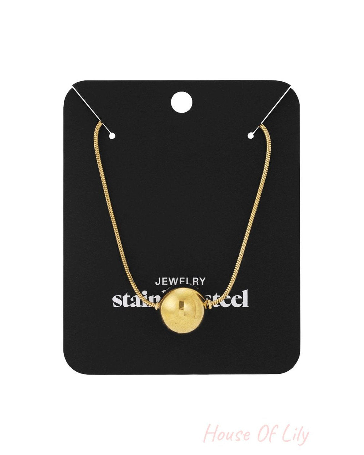 Elegant gold bead necklace featuring a single polished spherical pendant on a delicate chain, displayed on a black card.