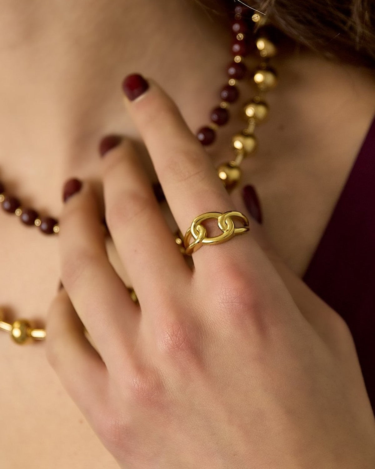 Knotted Magic Band: A polished gold chain-link style ring worn on a finger, featuring an interlocking looped design.