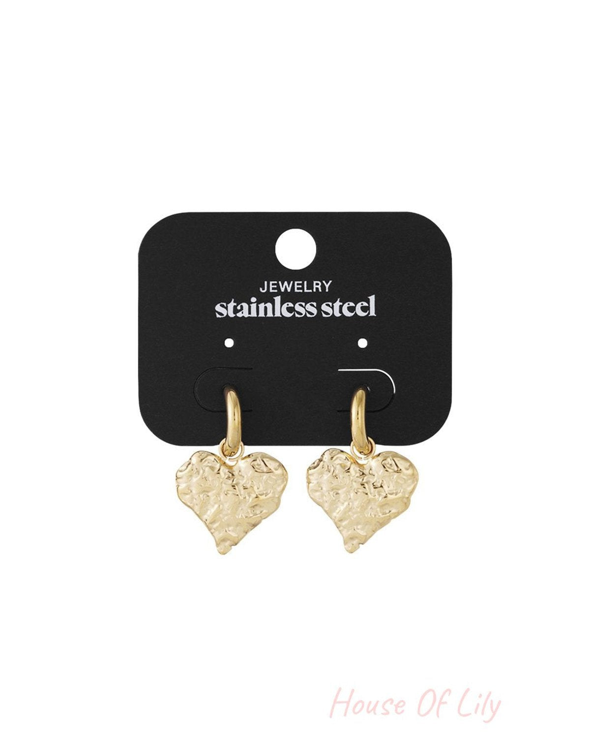 Gold-tone stainless steel hoop earrings featuring brushed, textured heart charms on a black display card.