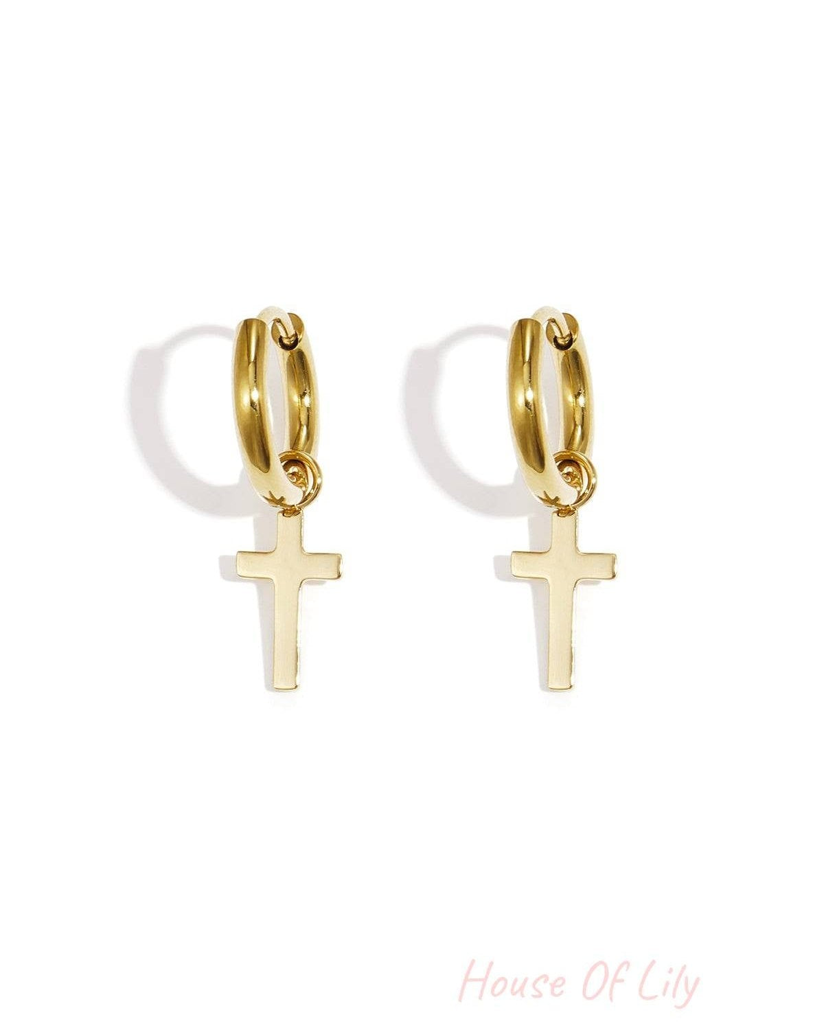 Pair of gold hoop earrings featuring delicate dangling cross pendants on a white background