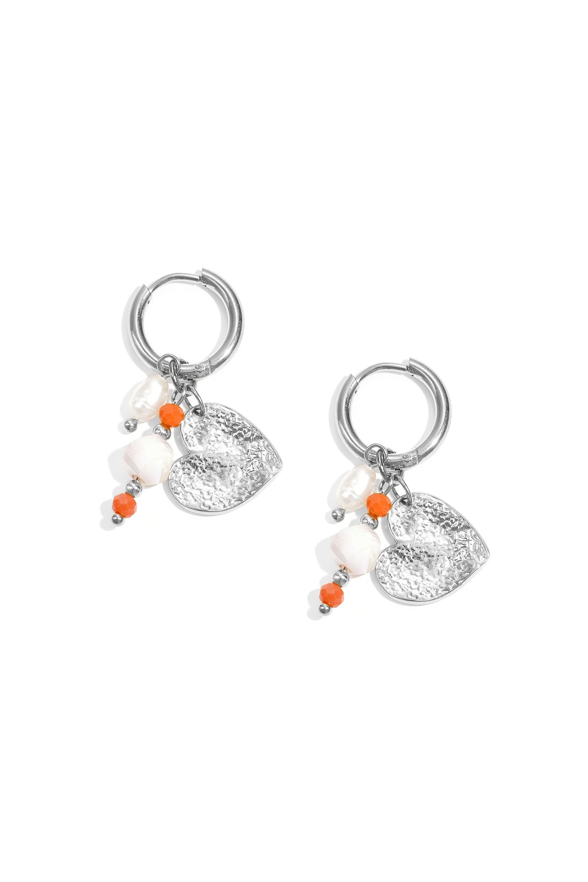 Pair of silver hoop earrings featuring hammered heart charm, pearls, and small orange and white beads on a white background