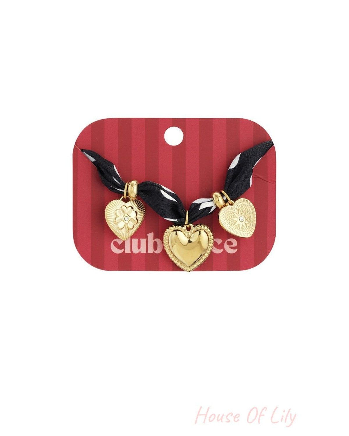 Polka dot fabric bracelet featuring three gold heart charms with intricate detailing and crystal accents on a red card.