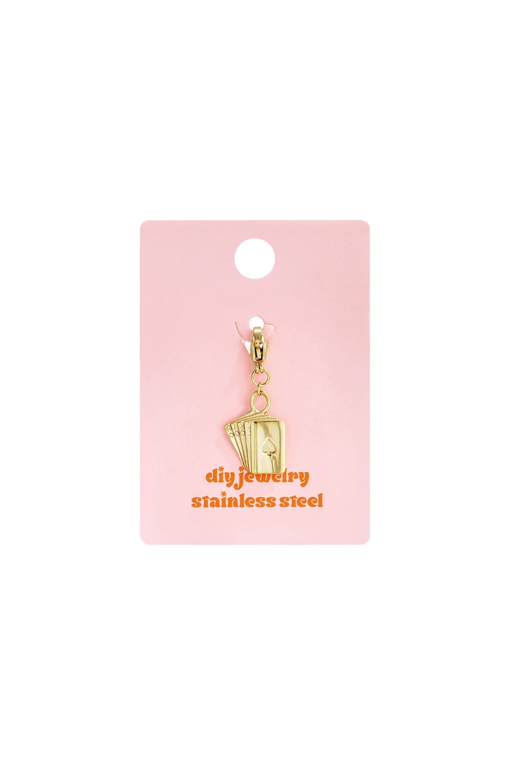 Gold Cards Era charm pendant on pink display card, featuring a miniature hand of playing cards in stainless steel.