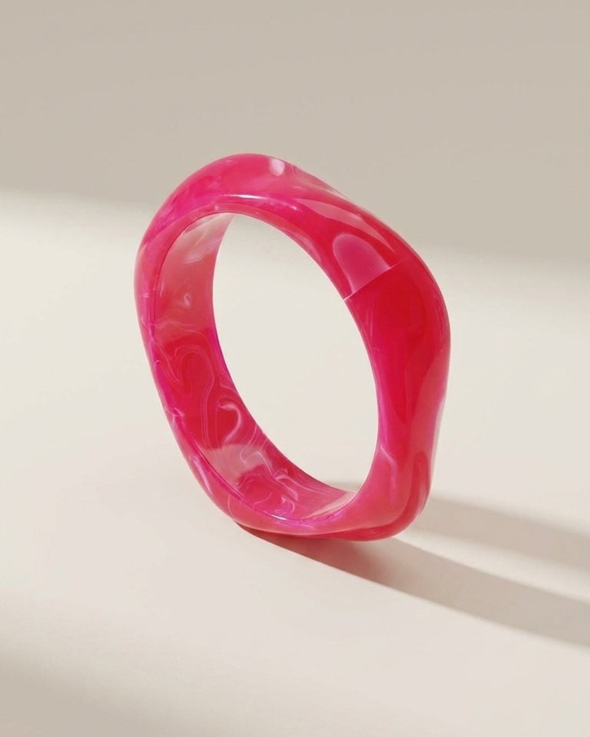 Hot pink acrylic statement bangle with a glossy, marbled finish and chunky style.