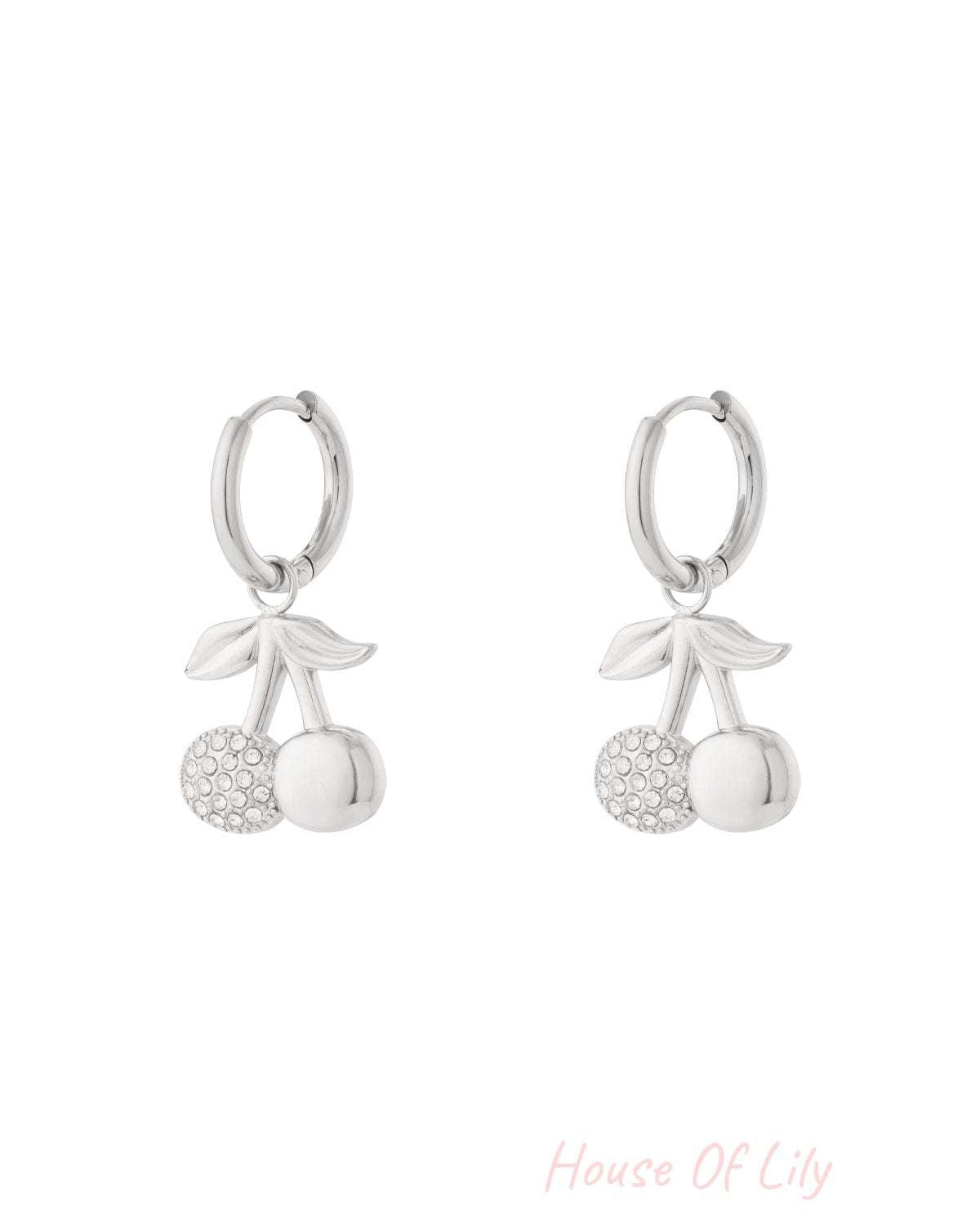 Pair of silver cherry drop earrings with rhinestone accents dangling from hoop earrings on white background