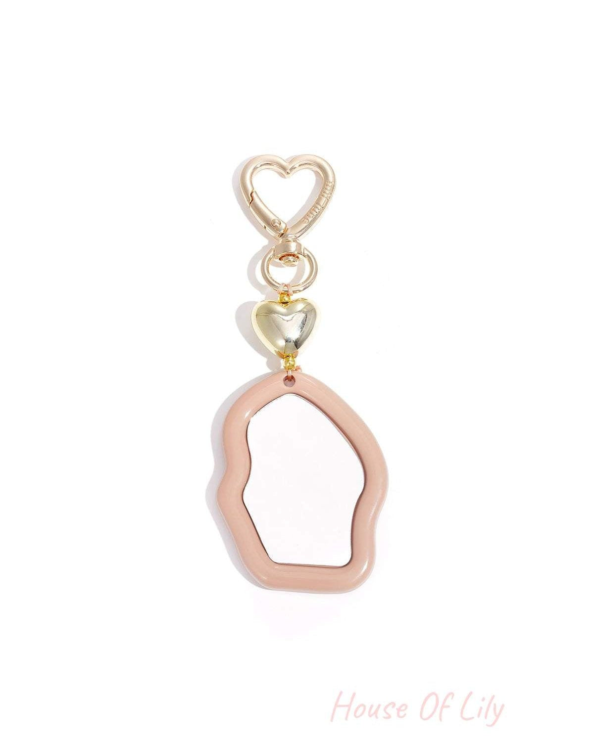 Blush pink acrylic irregular mirror charm with gold heart clasp on white background