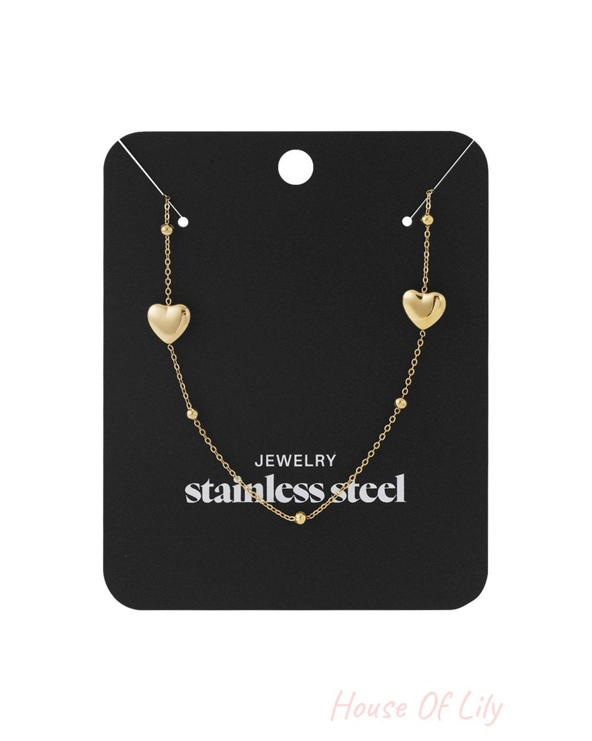 Gold-tone stainless steel Love Struck chain necklace featuring two small heart charms and delicate accent beads.