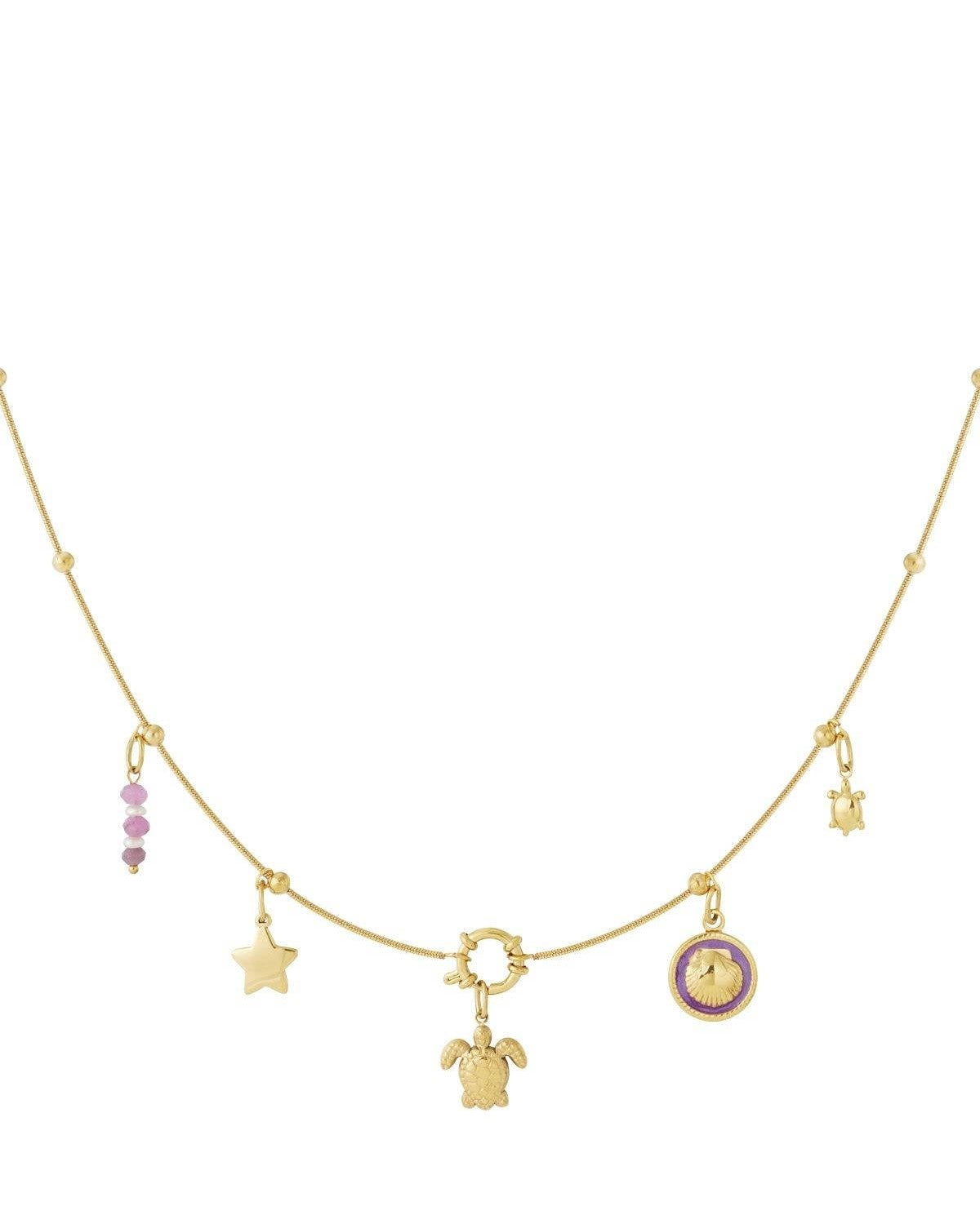 Flat lay of gold charm necklace showing detailed turtle, star, purple bead, small turtle and purple enamel shell charms on chain with spaced gold beads