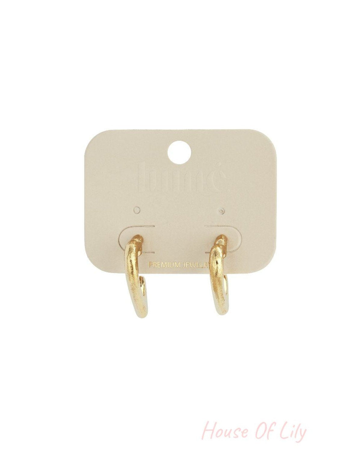 Gold puffy heart-shaped hoop earrings on a light beige display card.